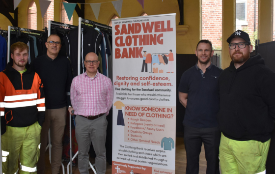 Image of people Infront of Sandwell Clothing Bank  banner