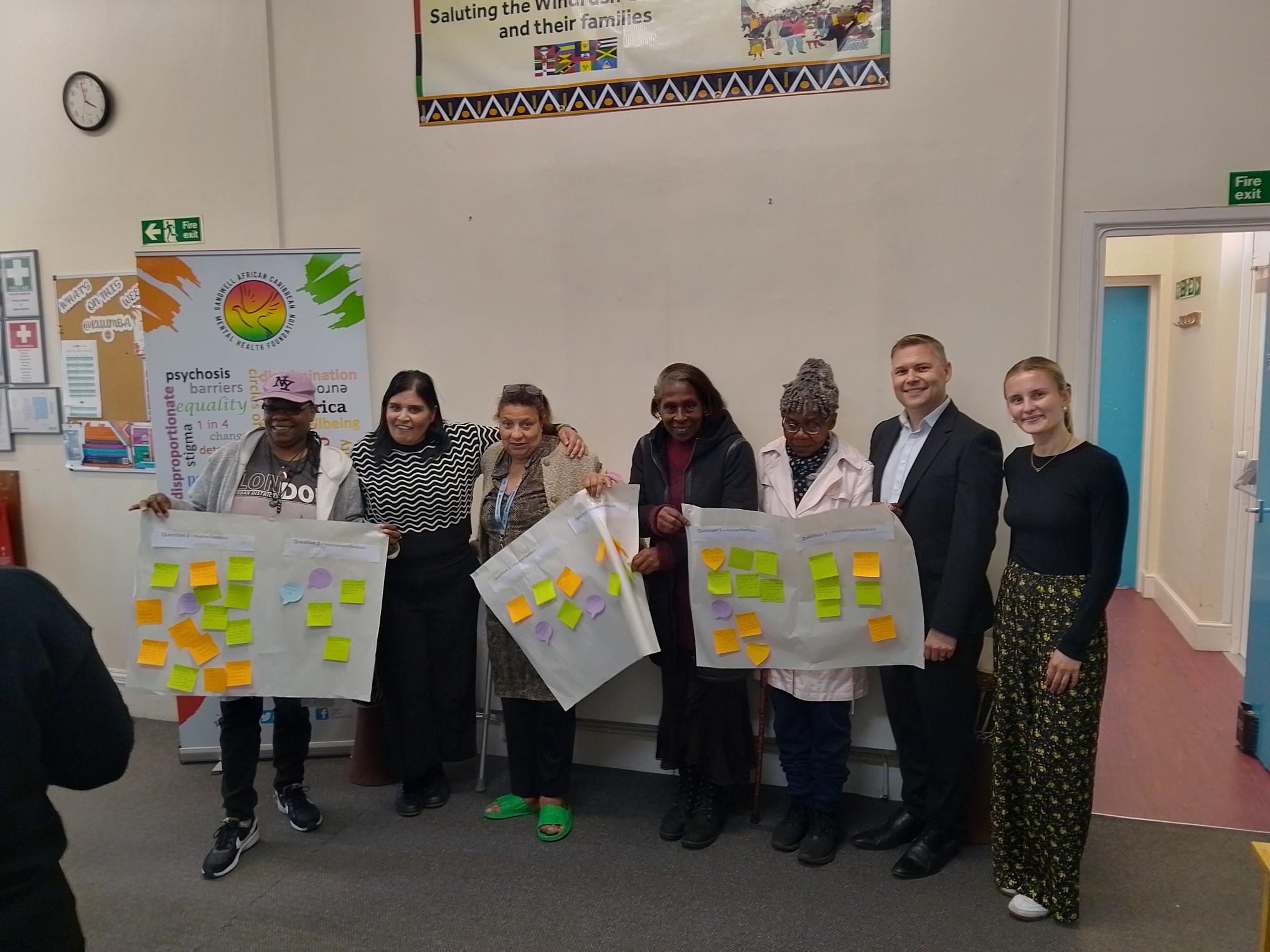 Carers and the Bridgit project team hold up flip chart paper and suggestions