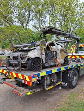 Vehicle being lifted on back of pick up truck