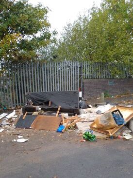 General waste dumped by side of alleyway