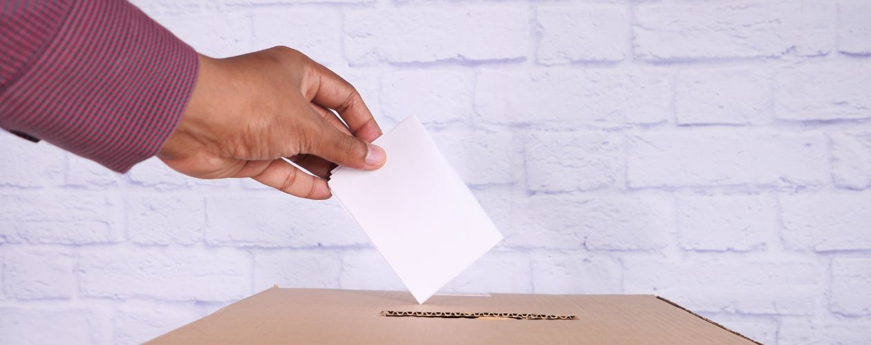 Image of man putting ballot paper in ballot box