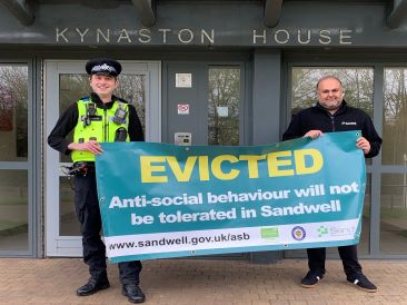 Officers with Evicted Banner outside building