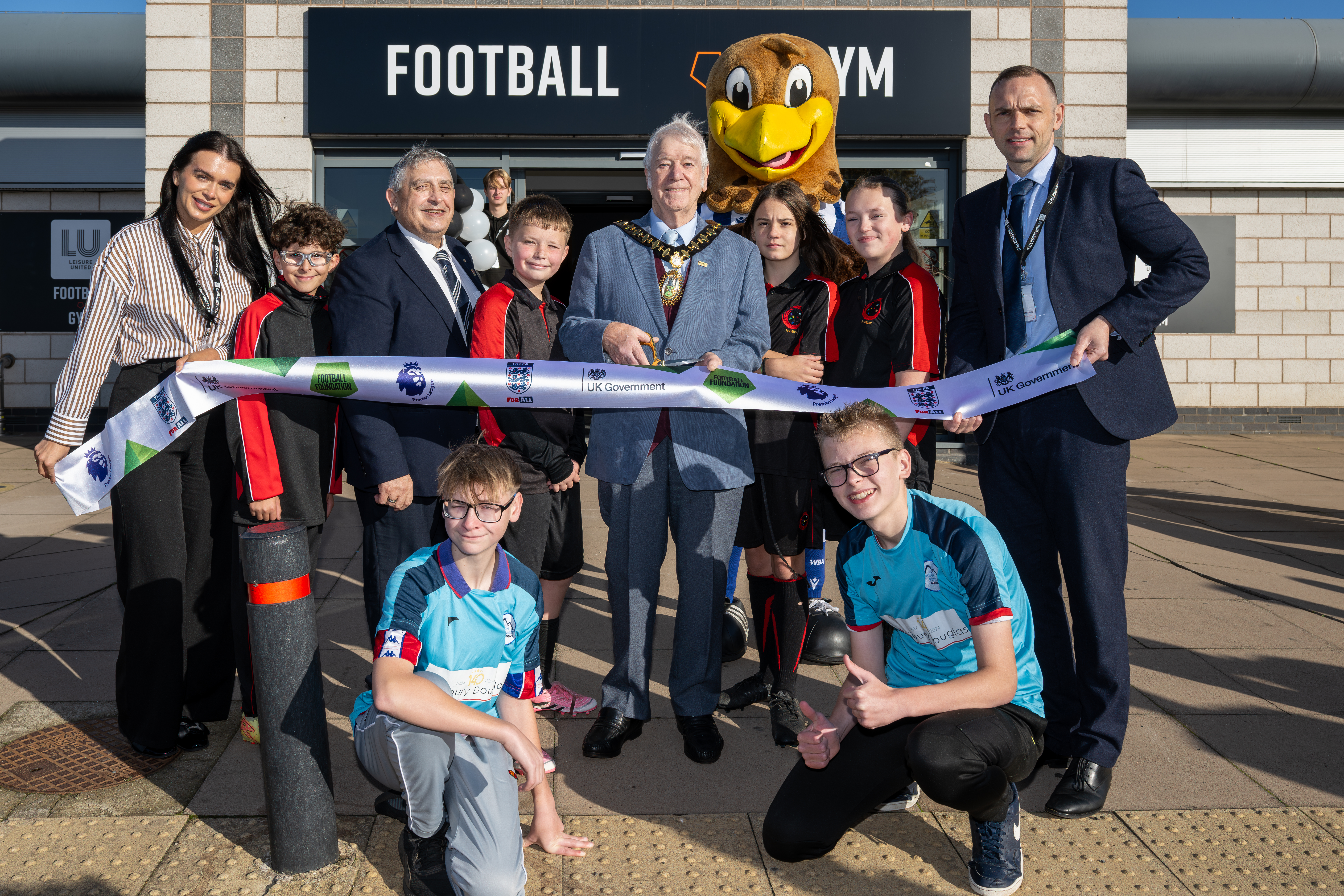 Children and dignatories cutting a ribbon at the launch of the Wednesbury hub