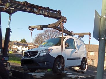 Abandoned vehicle being lifted for removal