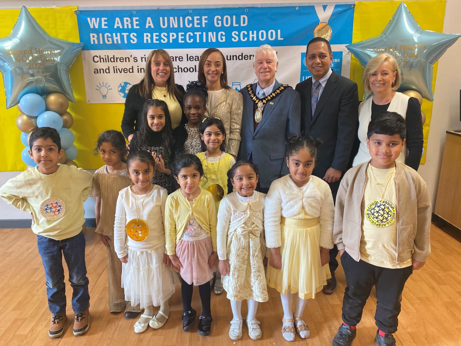 Headteacher Joy Agbonlahor with Mayor of Sandwell Councillor Steve Melia, Cabinet Member for Children and Families Councillor Jalal Uddin and Sacred Heart Primary pupils celebrating their UNICEF UK Rights Respecting Schools Gold Award