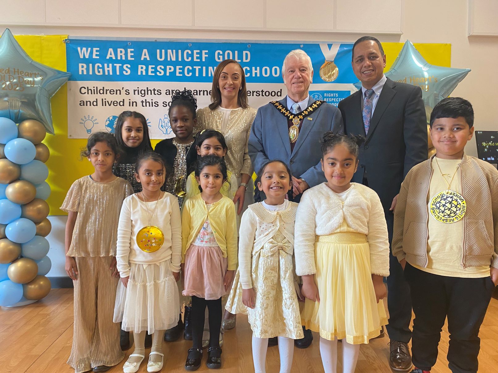 Headteacher Joy Agbonlahor with Mayor of Sandwell Councillor Steve Melia, Cabinet Member for Children and Families Councillor Jalal Uddin and Sacred Heart Primary pupils celebrating their UNICEF UK Rights Respecting Schools Gold Award