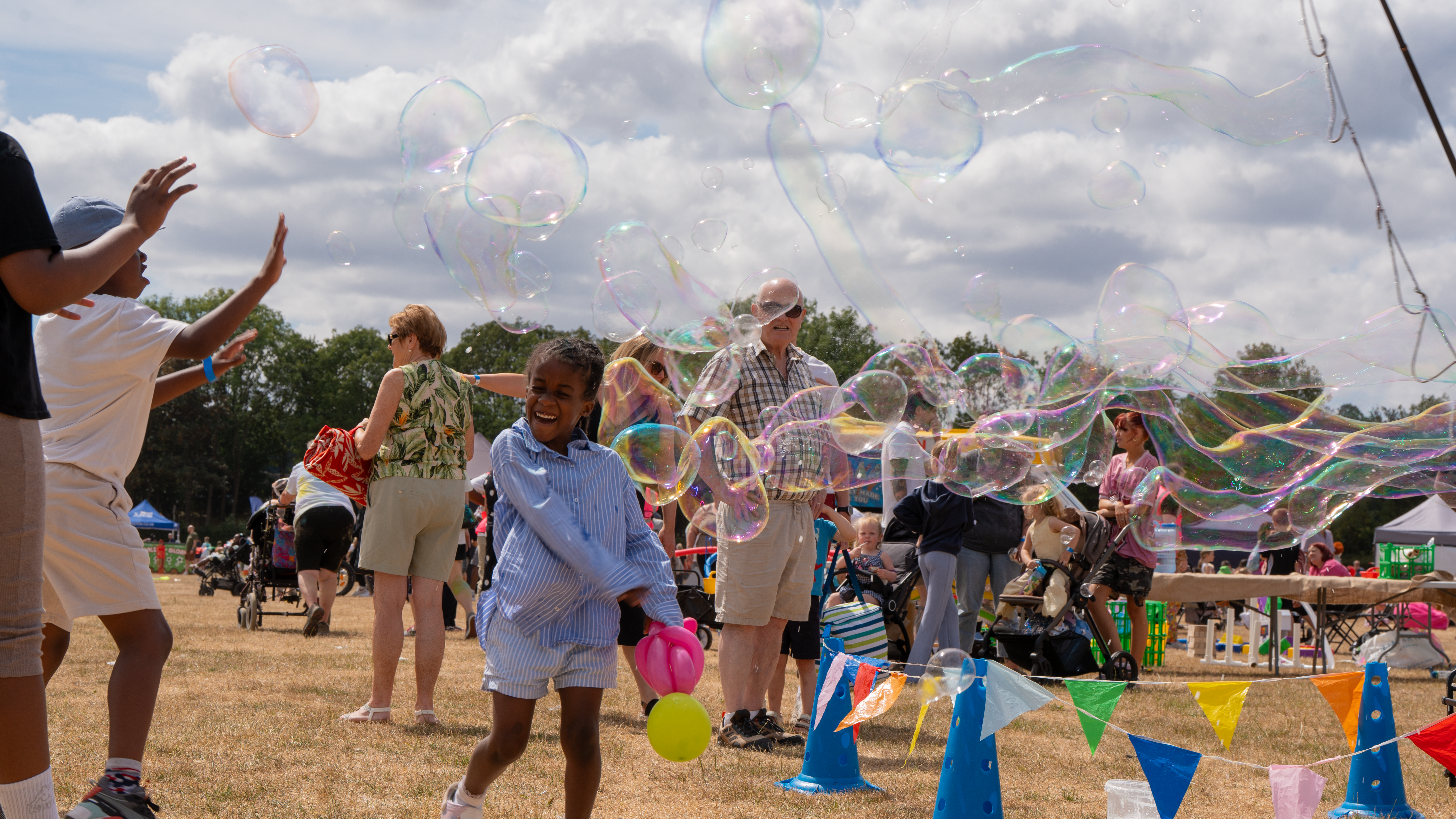 Smiling child blowing bubbles at a festival
