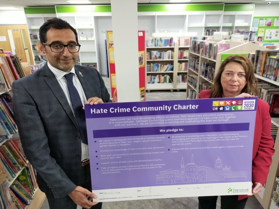Chief Executive Shokat Lal and Leader Councillor Kerrie Carmichael holding the Hate Crime Community Charter in Oldbury Library