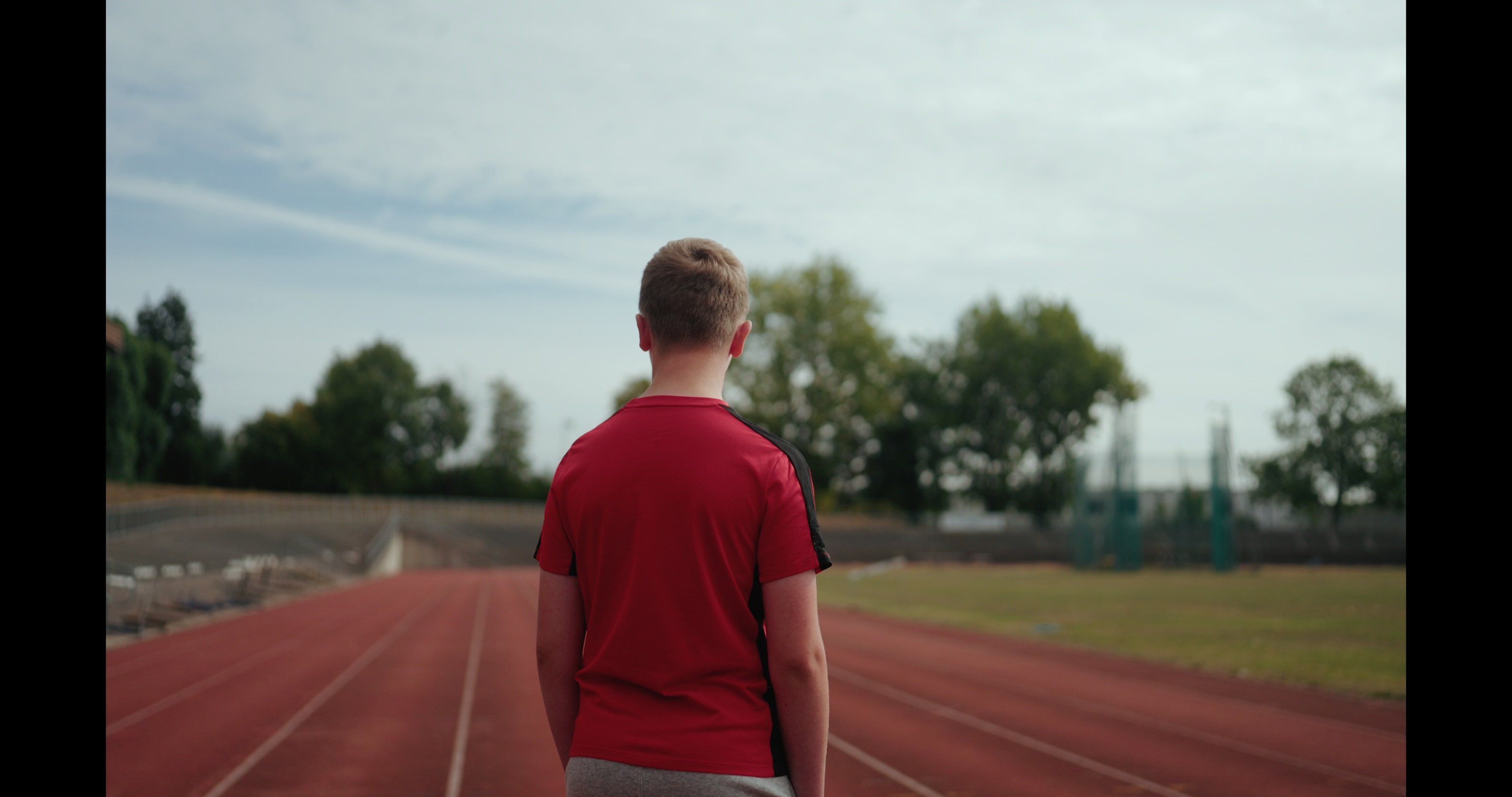 image of a boy with his back to the camera on a race track