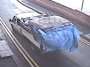 Rear view of white low back van carrying waste