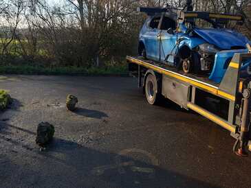 Damaged vehicle loaded on back of recovery truck