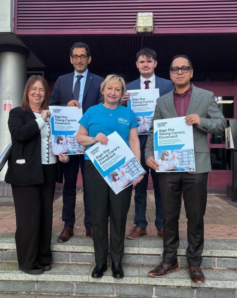 Group of leaders hold poster of the Young Carers Covenant