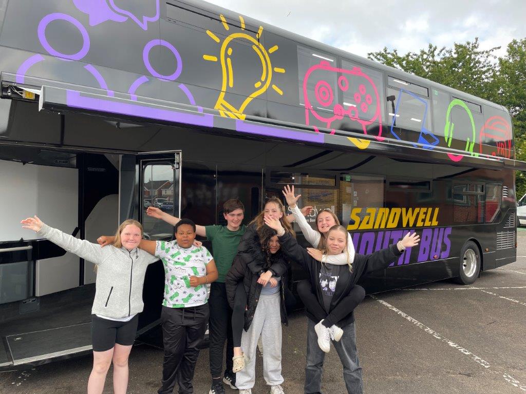 Young people stood next to Youth Bus